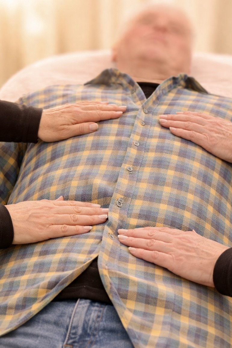 Sanfte Handauflegung beim Jin Shin Jyutsu zur Aktivierung des Energieflusses im Liegen